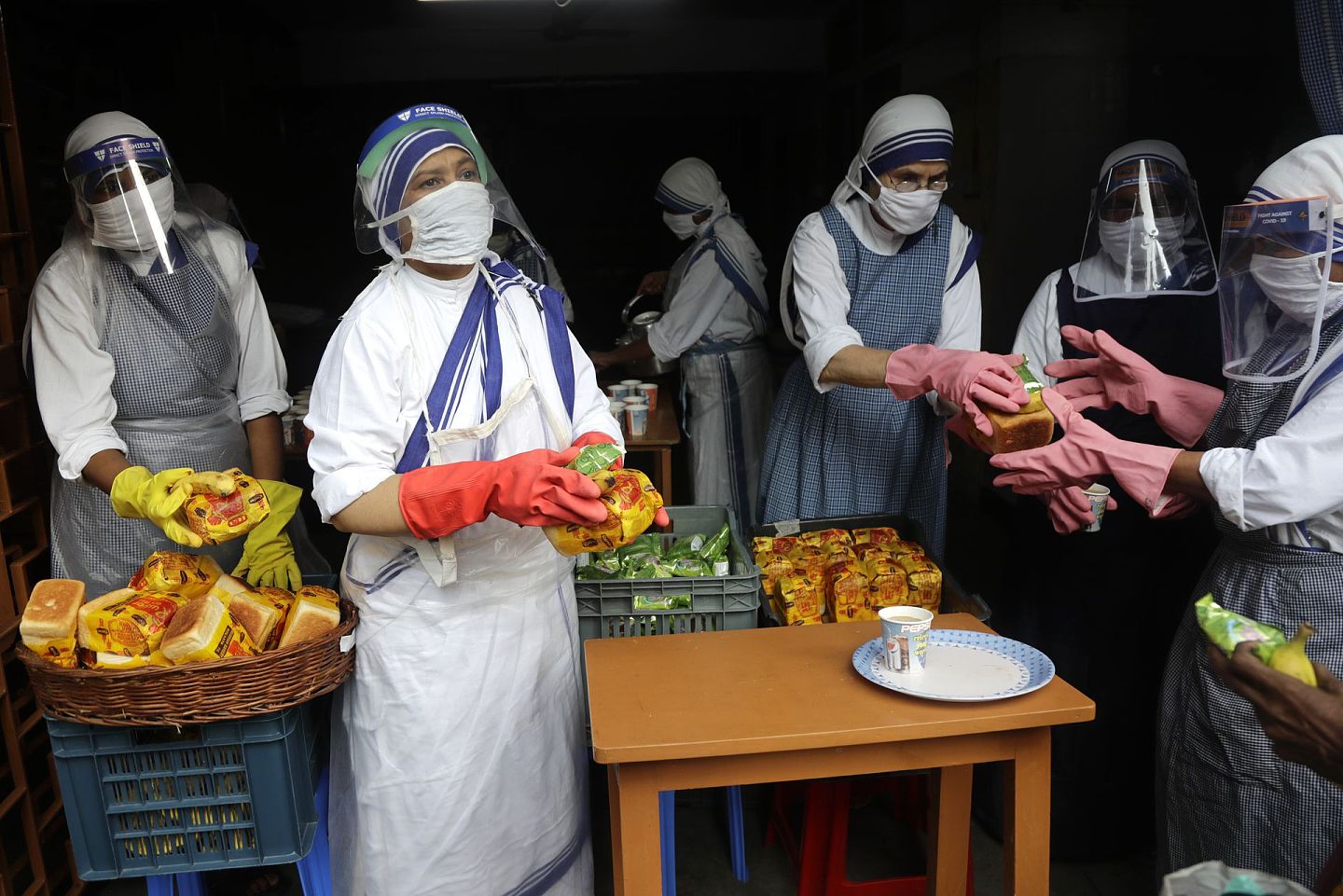 在加尔各答，圣特雷莎（Saint Teresa）创立的博济会的修士与修女也参与了慈善行动，不过他们在贫民面前已经保护停当。（美联社）