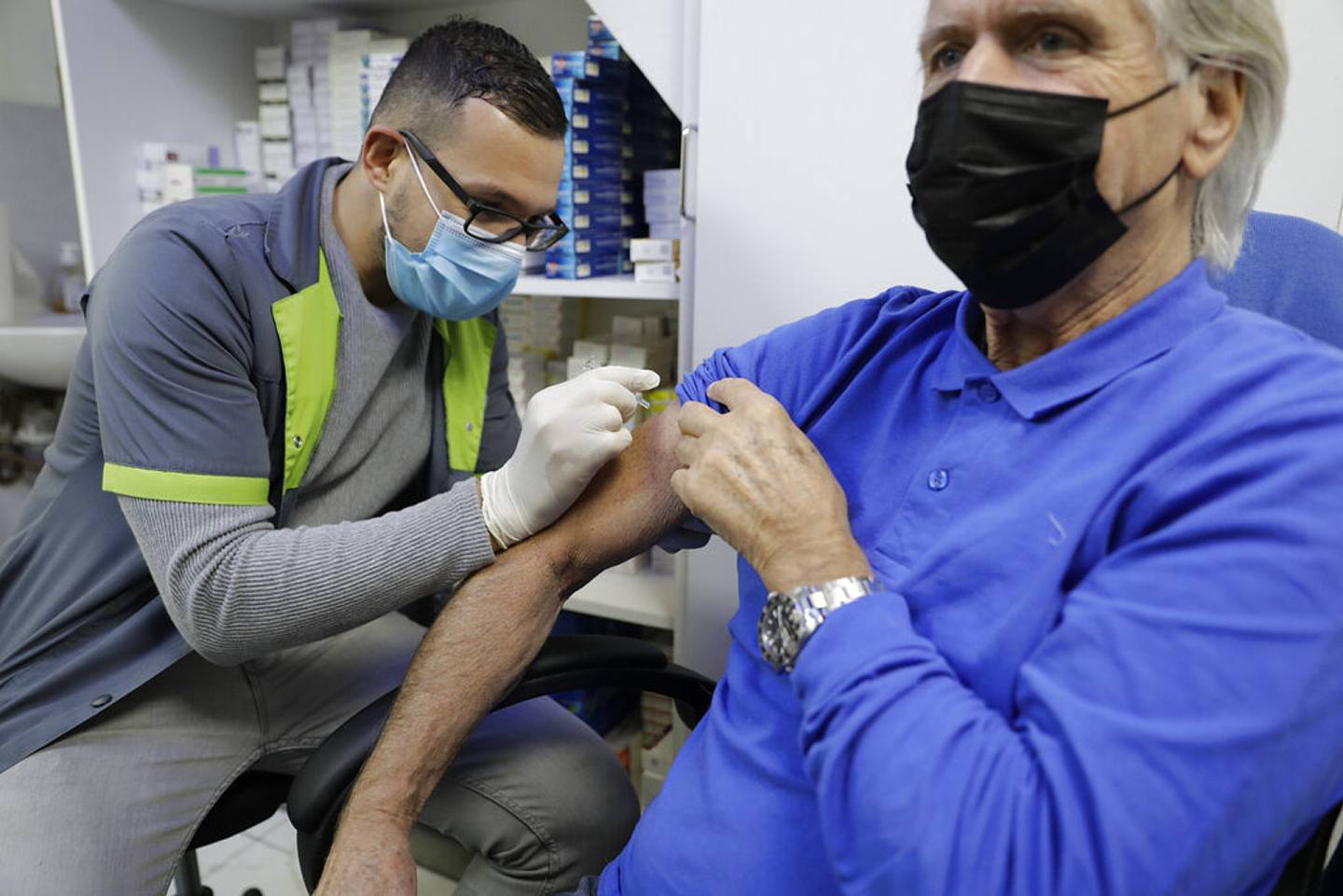 图为10月14日法国巴黎一名药剂师在药店为一名市民注射流感疫苗。 （AP）