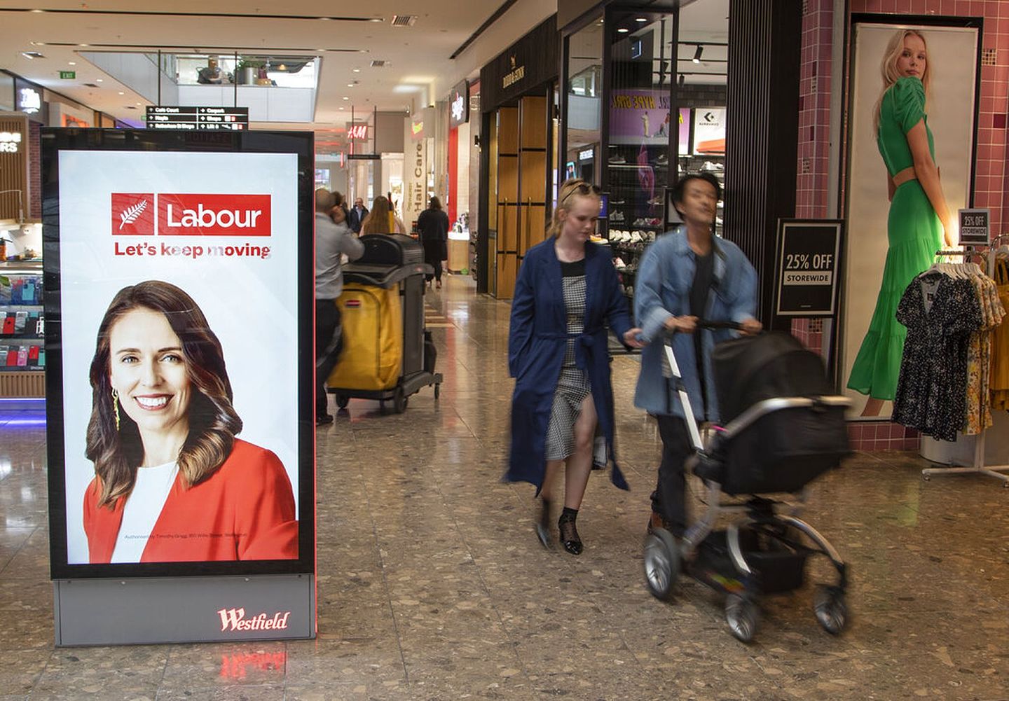 新西兰大选：图为基督城民众10月14日经过一个电子广告牌，广告牌当时正展示总理阿德恩的照片。（AP）