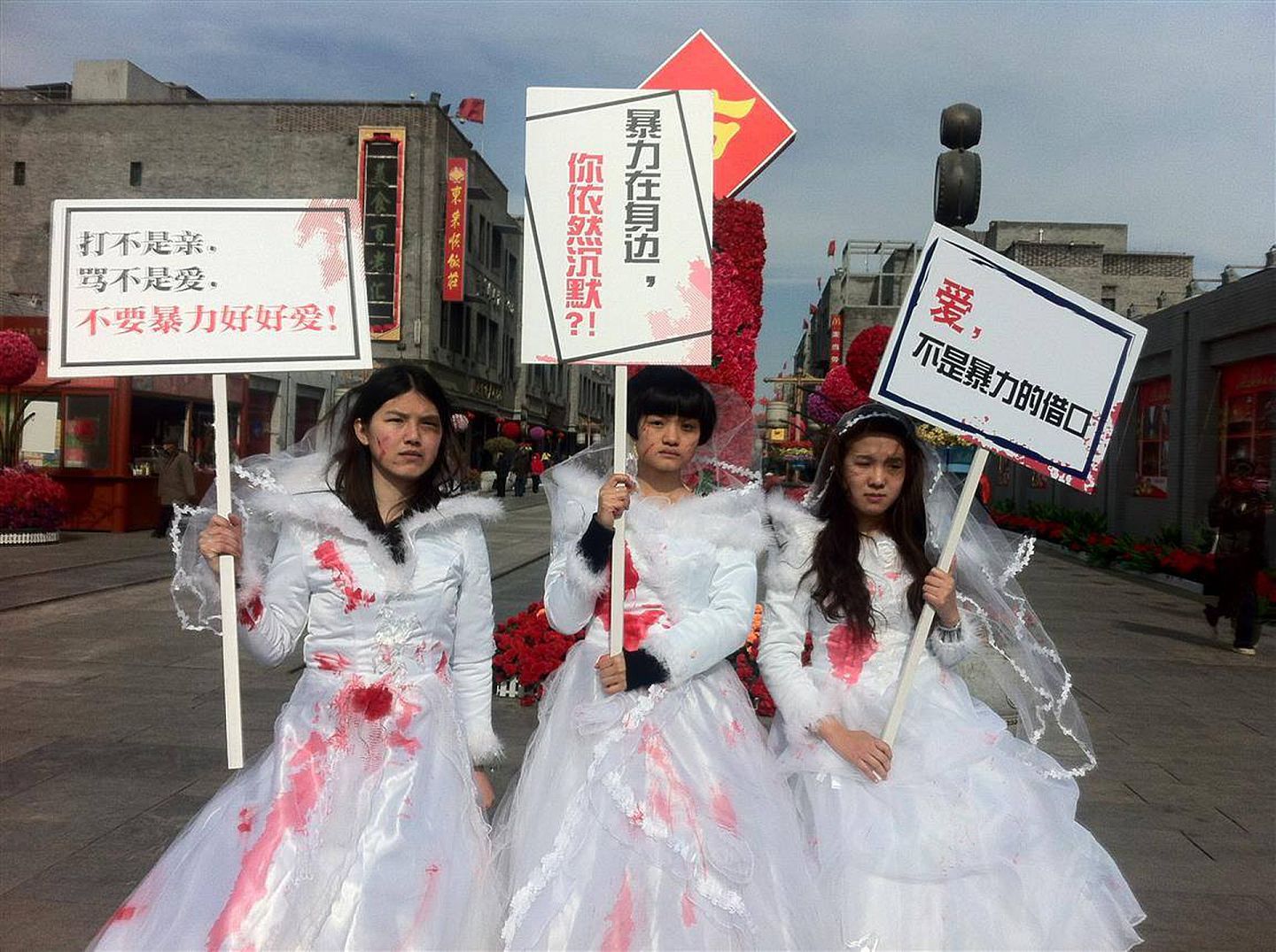 在中国，家庭暴力酿成的恶性事件并不罕见。图为2012年，三名女子在北京市街头穿上血淋淋的婚纱，希望社会关注家庭暴力受害者。(Facebook@Free Chinese Feminists)
