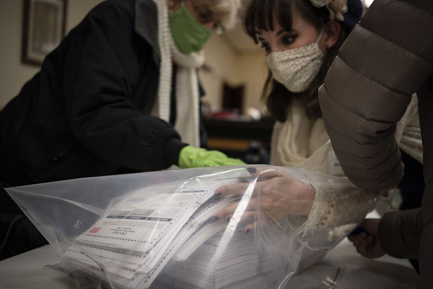 2020年11月3日，威斯康星州基诺沙，选举工作人员在驼鹿旅馆投票站关闭后整理选票。（AP)