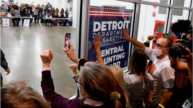 Trump supporters bang on the glass in Michigan where votes are being counted