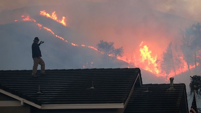 加利福尼亚州奇诺岗州立公园一名男子从大宅屋顶眺望迫近己方的丛林大火（27/10/2020）