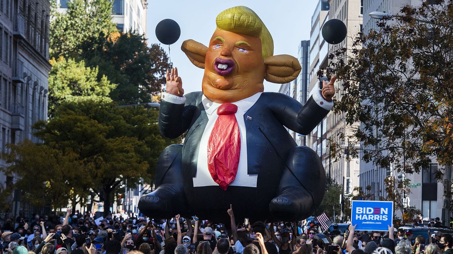 美国大选：图为11月7日，首都华盛顿有民众上街庆祝民主党总统候选人拜登胜选，他们展示一个讽刺总统特朗普、丑化他外貌的巨型气球。（Getty）