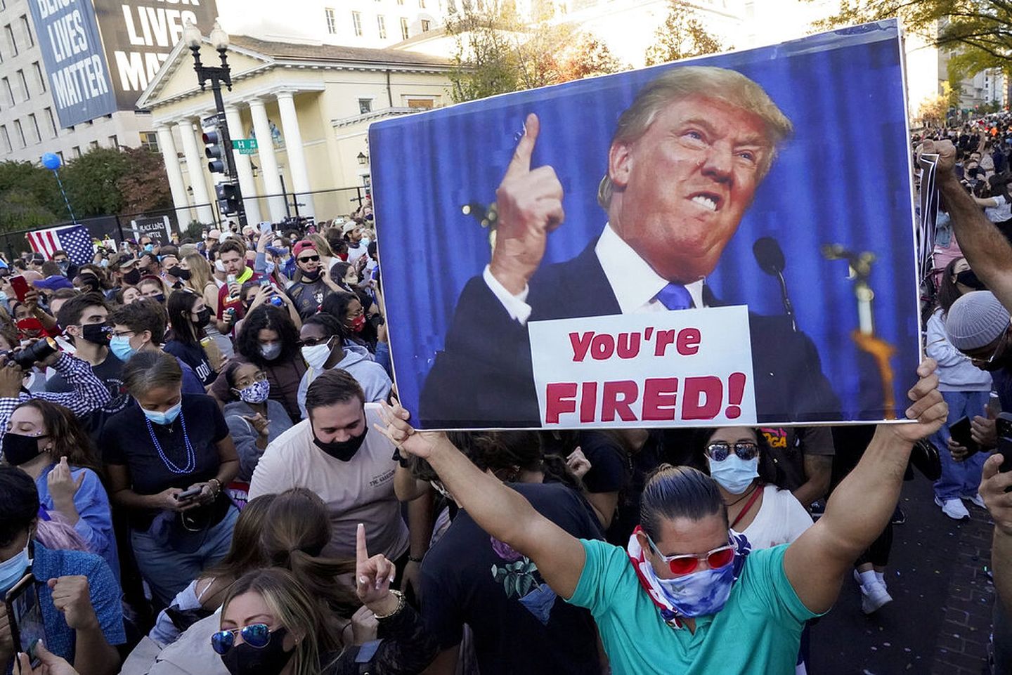 11月7日，拜登的支持者在华盛顿举起标语牌，上面印有特朗普的肖像以及标语“You're Fired！”(AP)