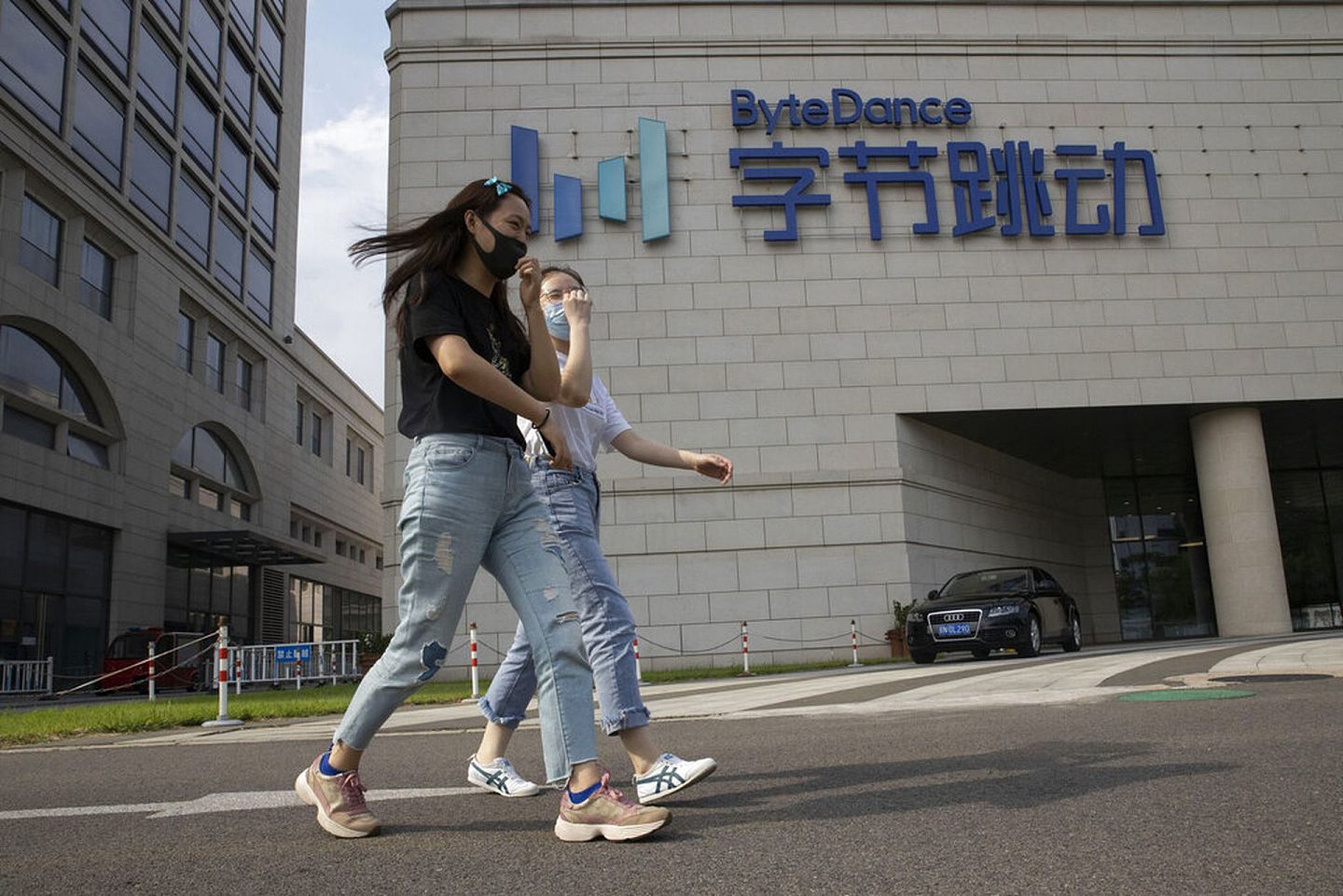 美国政府近来对TikTok展开了不遗余力的“追杀”。图为2020年8月7日，两名女子走过位于中国北京的TikTok母公司字节跳动总部。（AP）