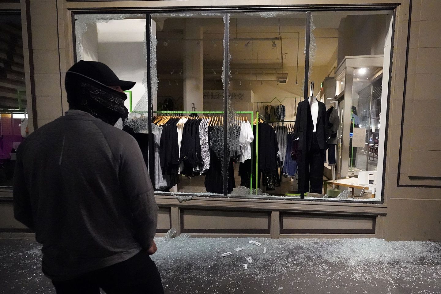 反对特朗普的暴徒攻击了波特兰市的建筑物。图为11月4日，一名男子在骚乱后站在一家被破坏的店铺门外。（AP）