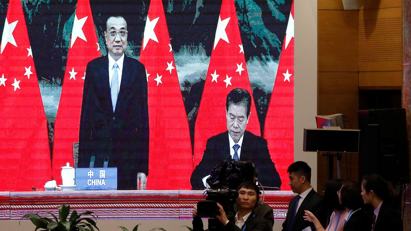 中国国务院总理李克强（左）与中国商务部长钟山（右）以视像形式出席越南河内的东盟峰会，期间签署RCEP。（Reuters）