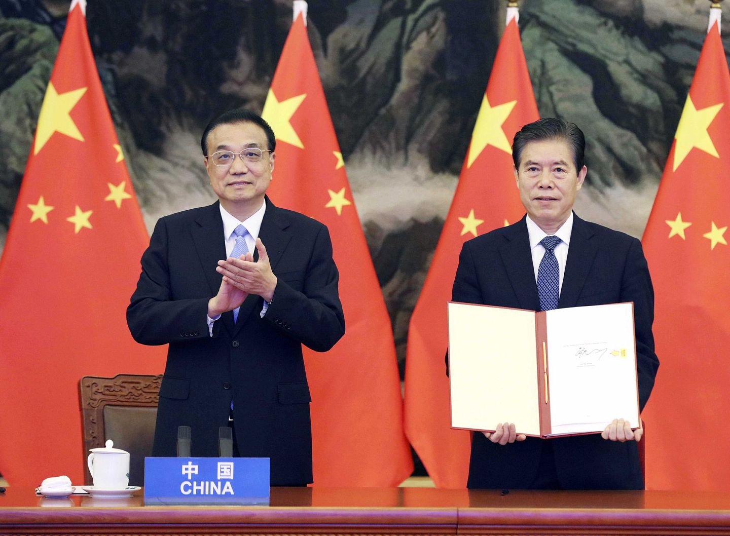 2020年11月15日， 中国总理李克强（左）在北京人民大会堂参加RCEP领导人会议。东盟十国以及韩国、日本、澳大利亚、新西兰等国家领导人与会，会议以视频形式举行。（新华社）