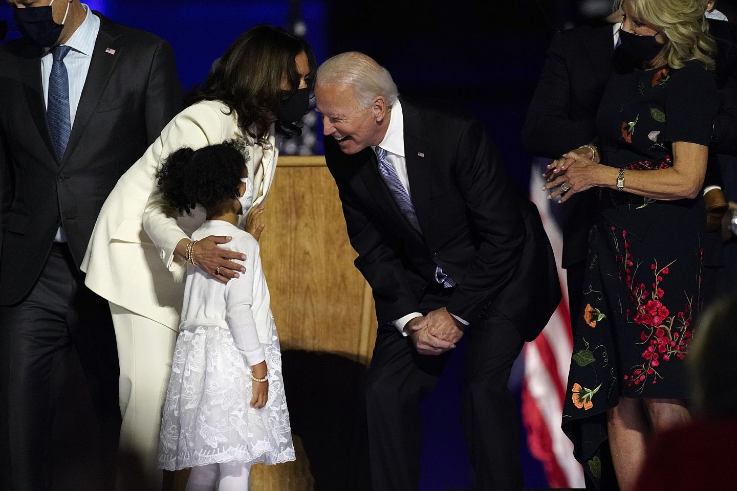 11月7日，演讲结束后，拜登与副总统当选人贺锦丽（Kamala Harris）及他们的家人站在台上，满面笑容的拜登与一名女童交谈。（AP）