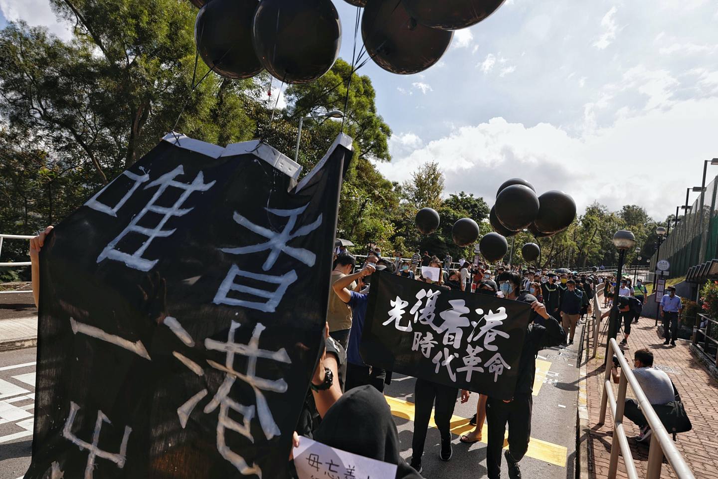 毕业生在校内游行，展示「光复香港时代革命」、「香港独立唯一出路」等旗帜标语。 （曾梓洋摄）