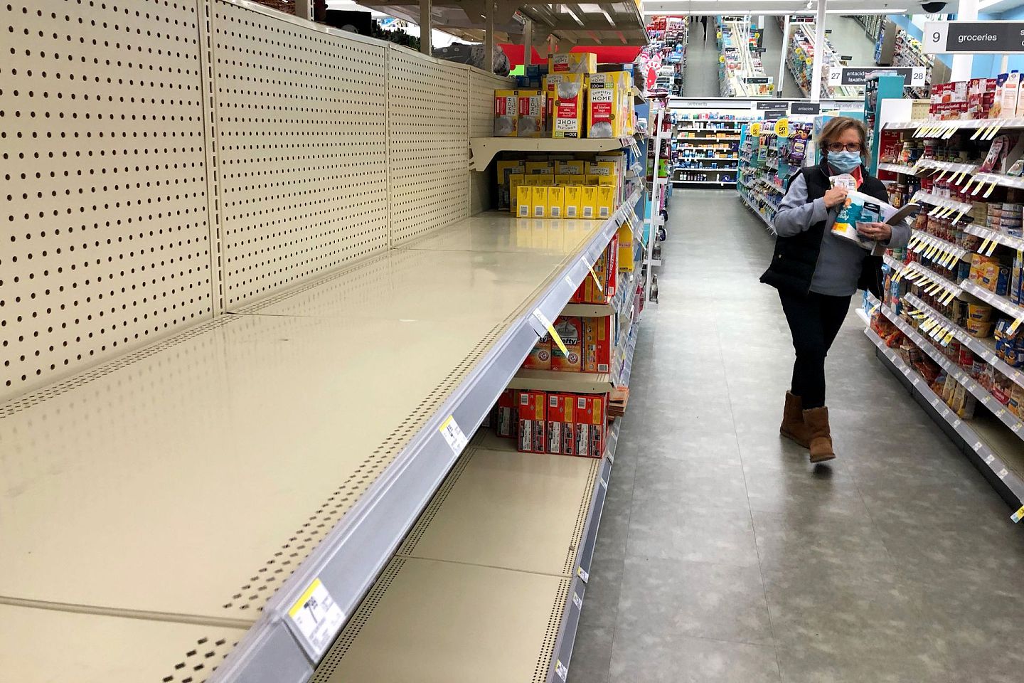 11月18日，美国伊利诺伊州库克县一个沃尔格林超级市场的厕纸货架遭清空。美国病例急剧增加，令民众再到超市囤货。有零售商被迫实际限购措施。（AP）