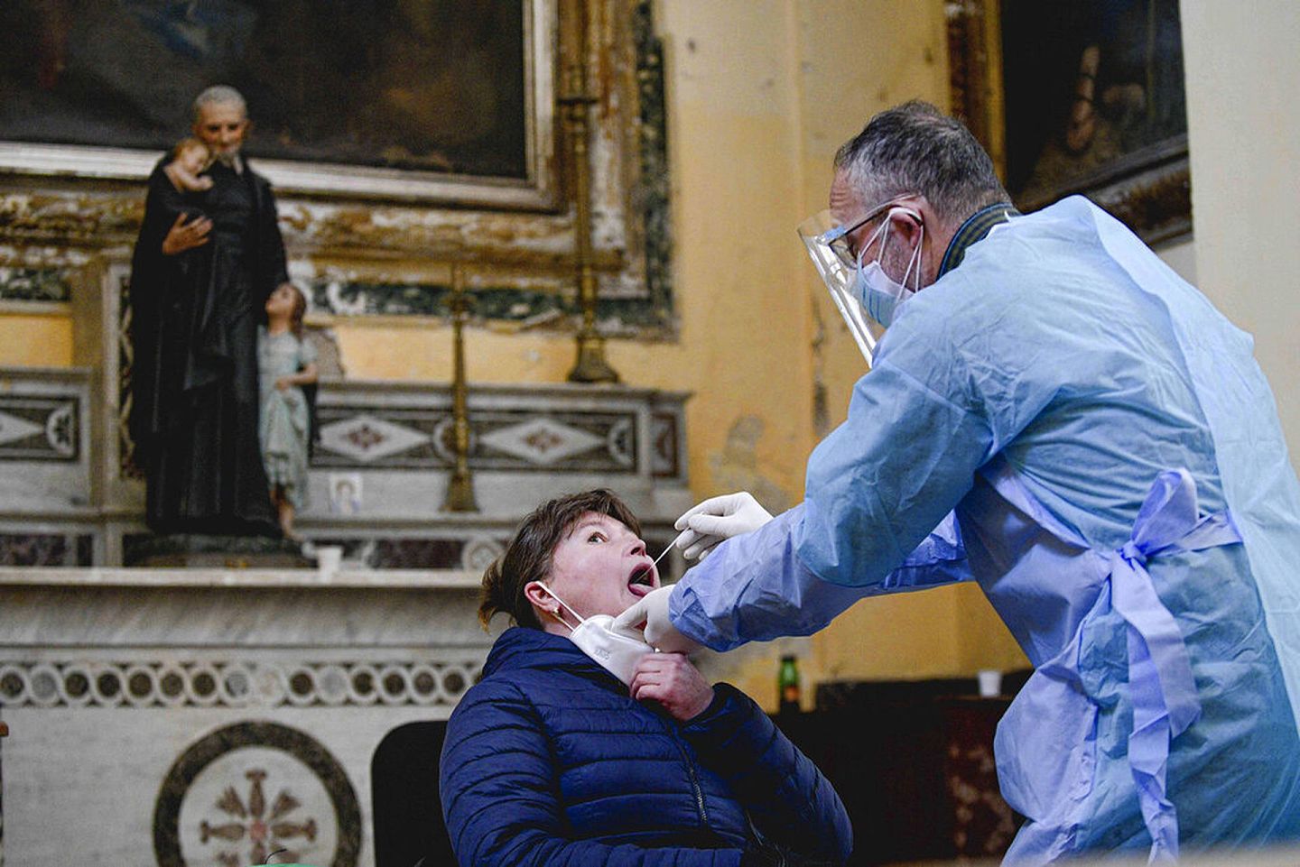 11月18日，意大利那不勒斯一所教堂内，一名医疗操作员在为人进行拭子测试。（AP）