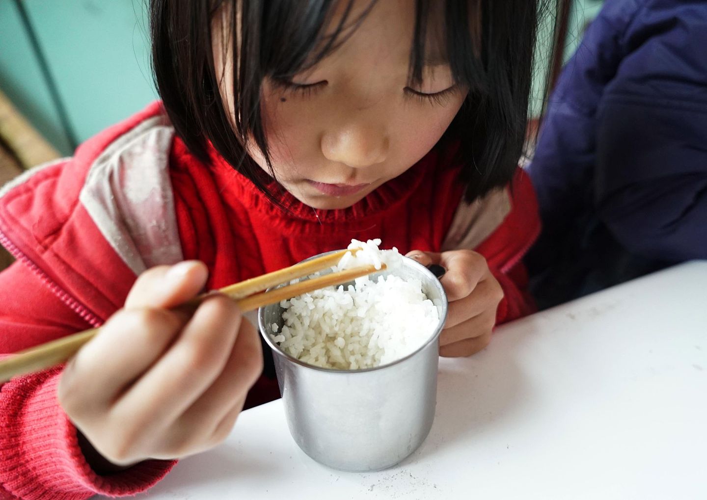 图为2014年江西省修水县大椿乡柏树村小学学生杨欣在吃自带的午饭。中国的贫困人口规模庞大，且造成贫困的原因也是各有不同。（新华社）