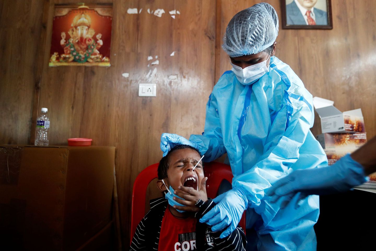 进入11月下旬后，印度的新冠疫情态势越发危急，图中为孟买一名医生为当地幼童采集咽拭子用以检测新冠病毒。（路透社）