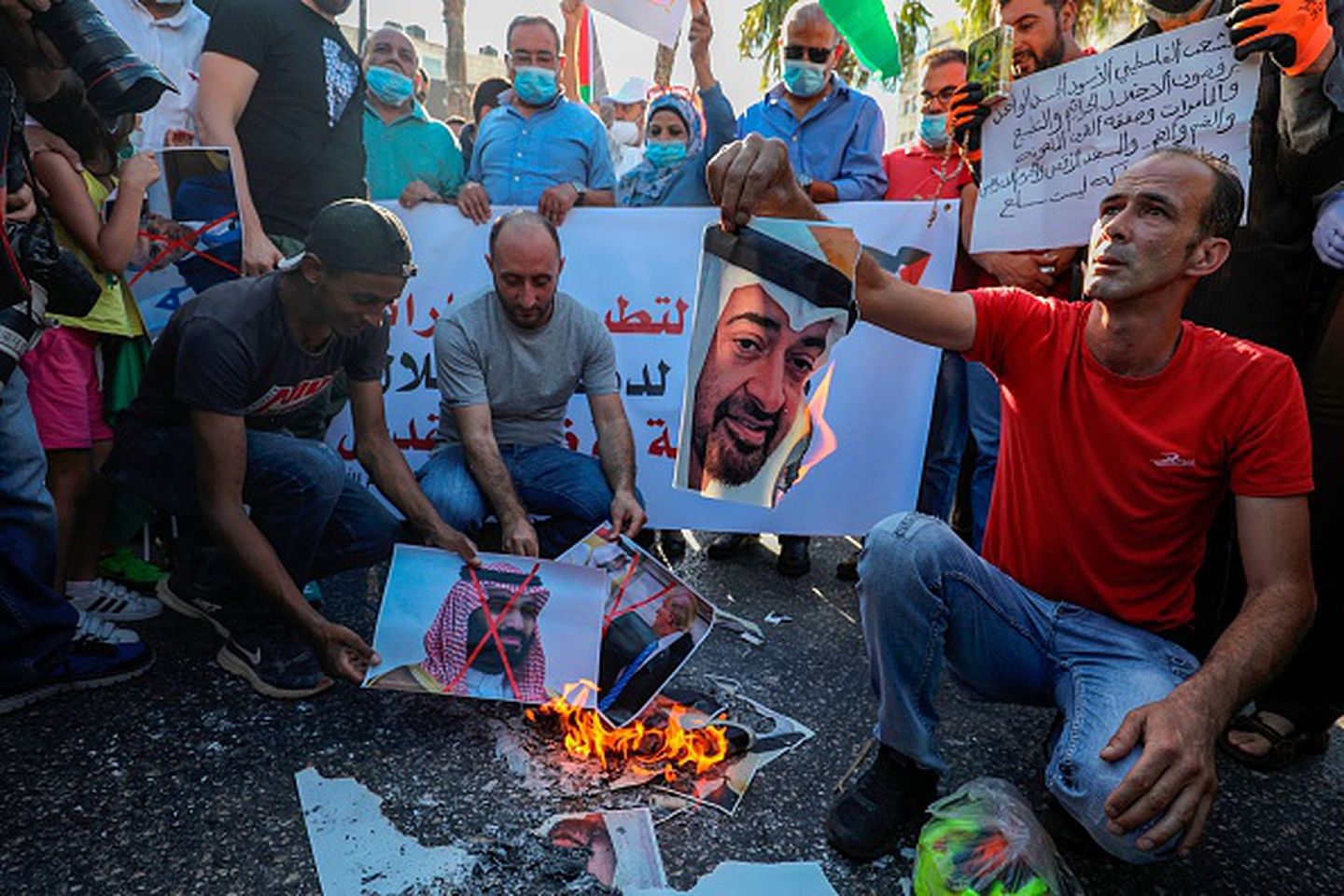 2020年8月15日，在约旦河西岸城市拉马拉的示威活动中，巴勒斯坦抗议者焚烧沙特王储本.萨勒曼的画像,以示对王储本人“媾和以色列”之举的强烈不满。（Getty Images）