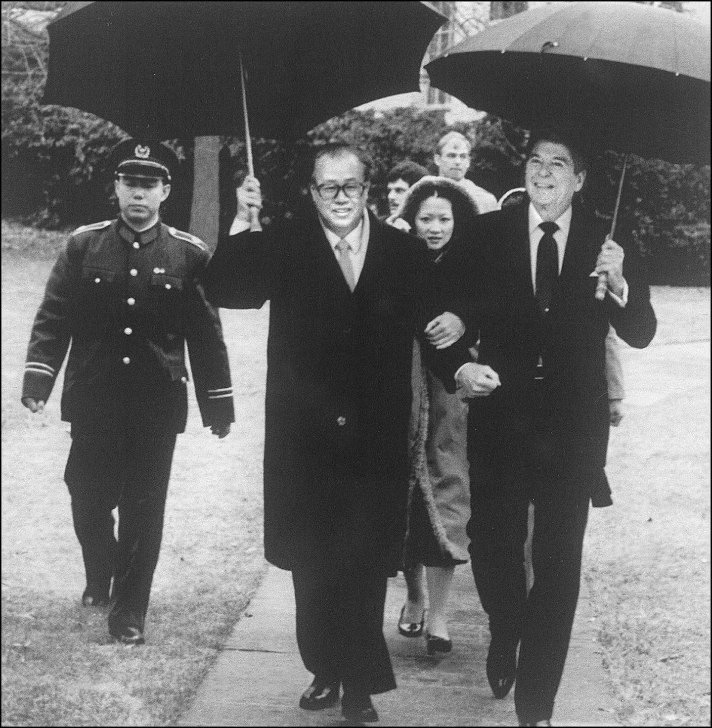1984年1月，中国国务院总理赵紫阳访美，与美国总统里根（右）一起撑伞手挽手并肩而行。（法新社）