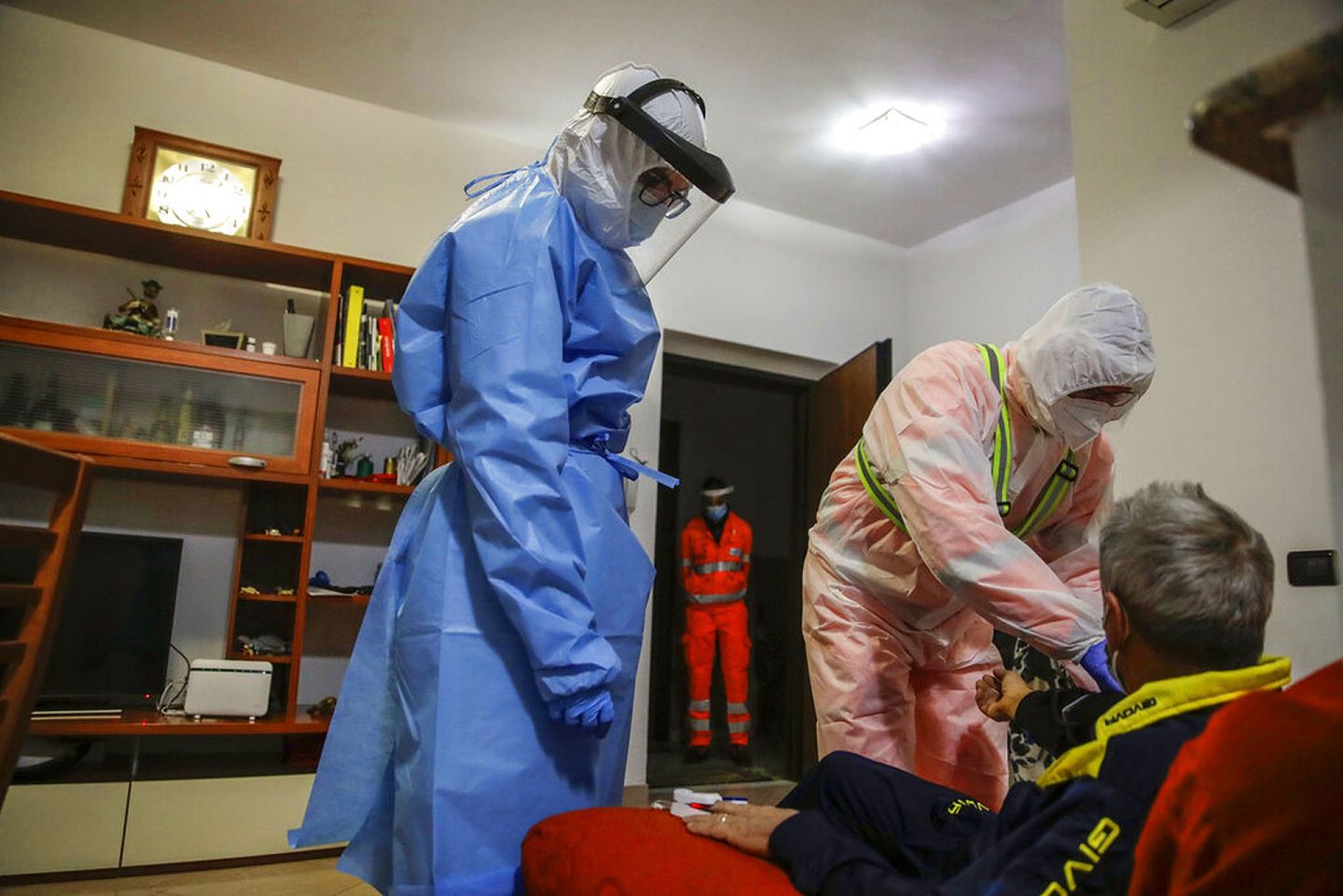 意大利新冠肺炎疫情：医务人员加里博尔迪（右）在公寓楼里测量一名疑似新冠肺炎患者血液中的氧含量。（AP）