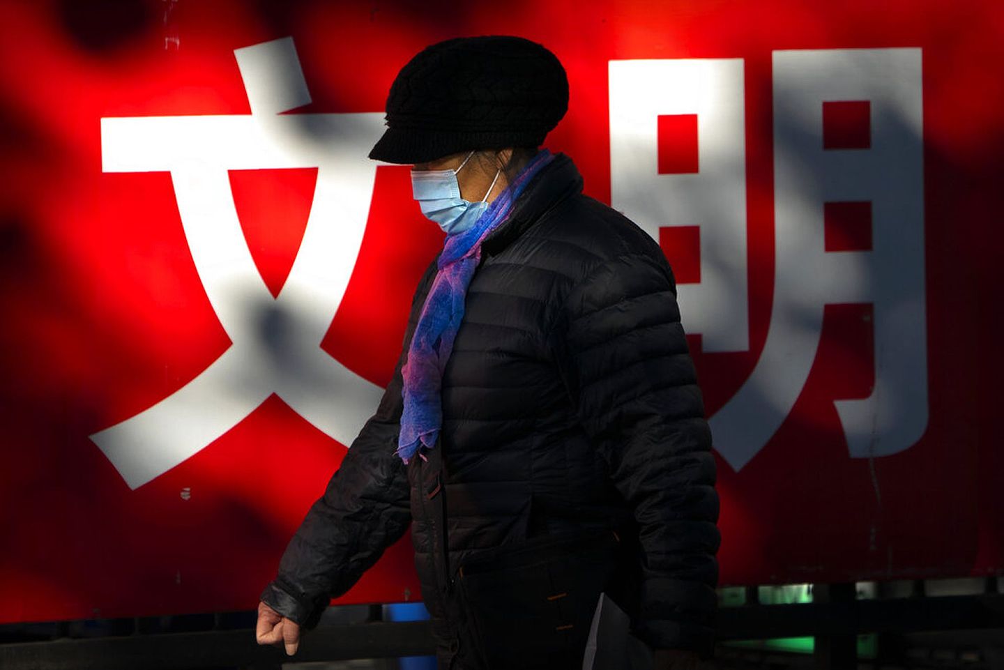 中国新冠肺炎疫情：图为11月20日一名女子走在北京的街道上。（AP）