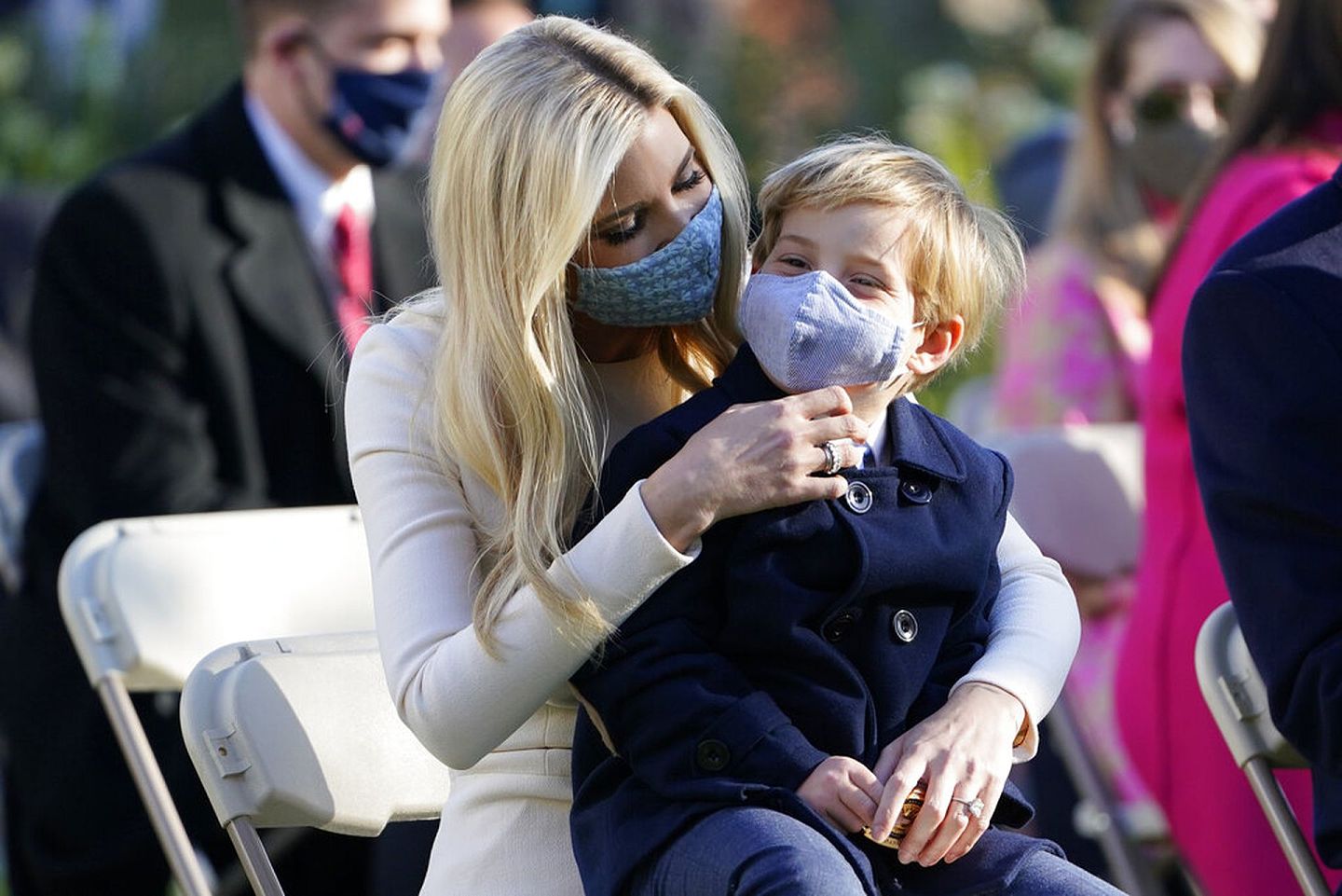 伊万卡给儿子西奥多整理口罩。（AP）