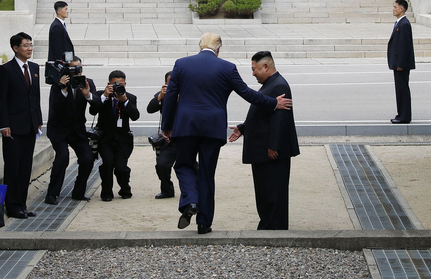 2019年6月30日，正在韩国访问的特朗普在板门店与金正恩握手会面后，跨越军事分界线来到朝方一侧。（新华社）