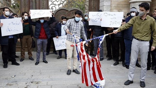 Students wearing facemasks and holding signs saying 