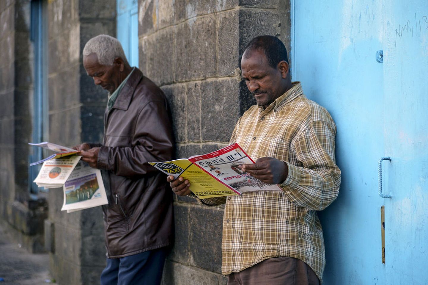 图为11月7日，在埃塞俄比亚首都亚的斯亚贝巴，埃塞俄比亚人阅读报道该国当前军事对抗的报纸和杂志。(美联社/Samuel Habtab)