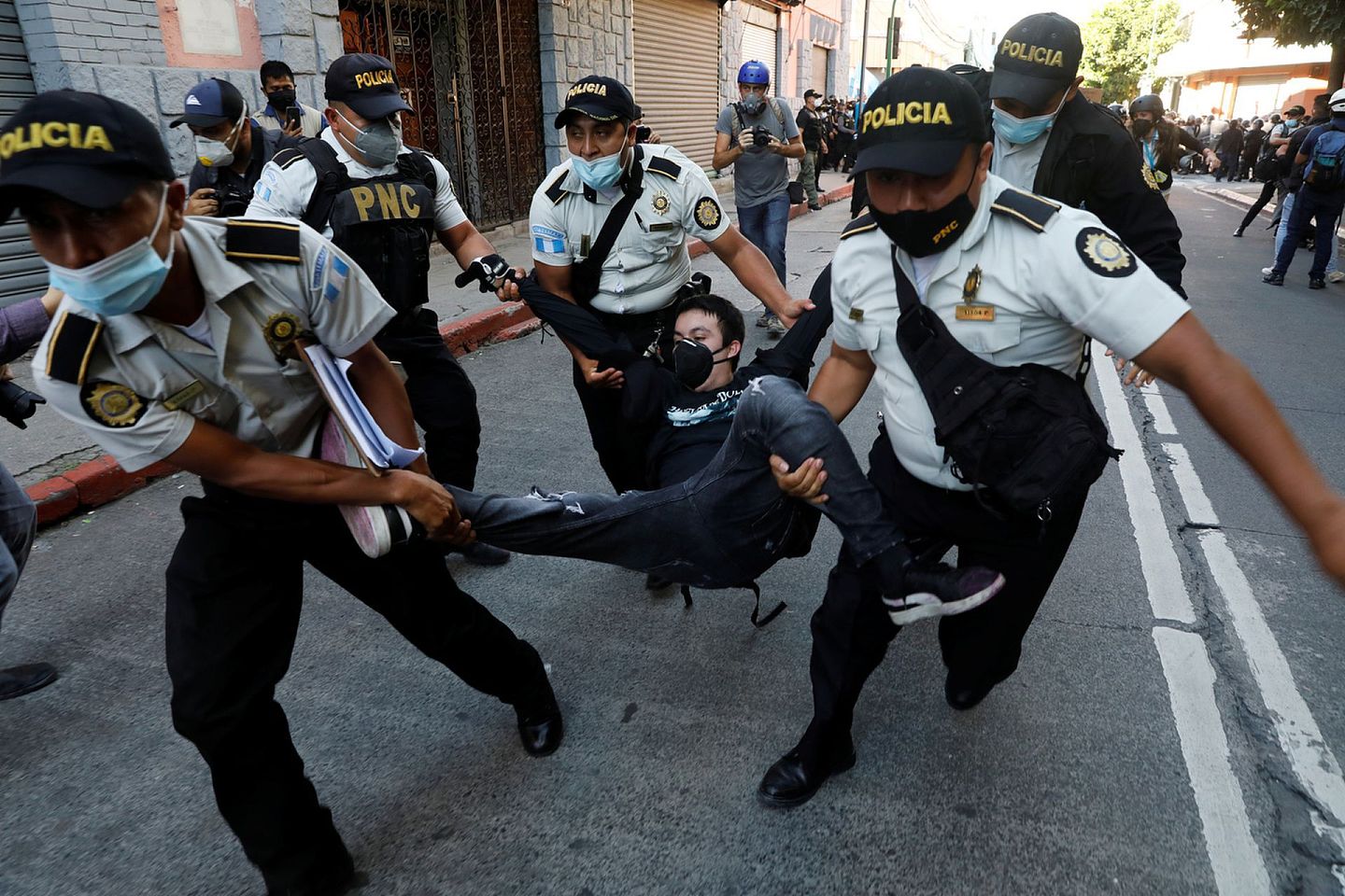 危地马拉警员抬走示威者。（Reuters）