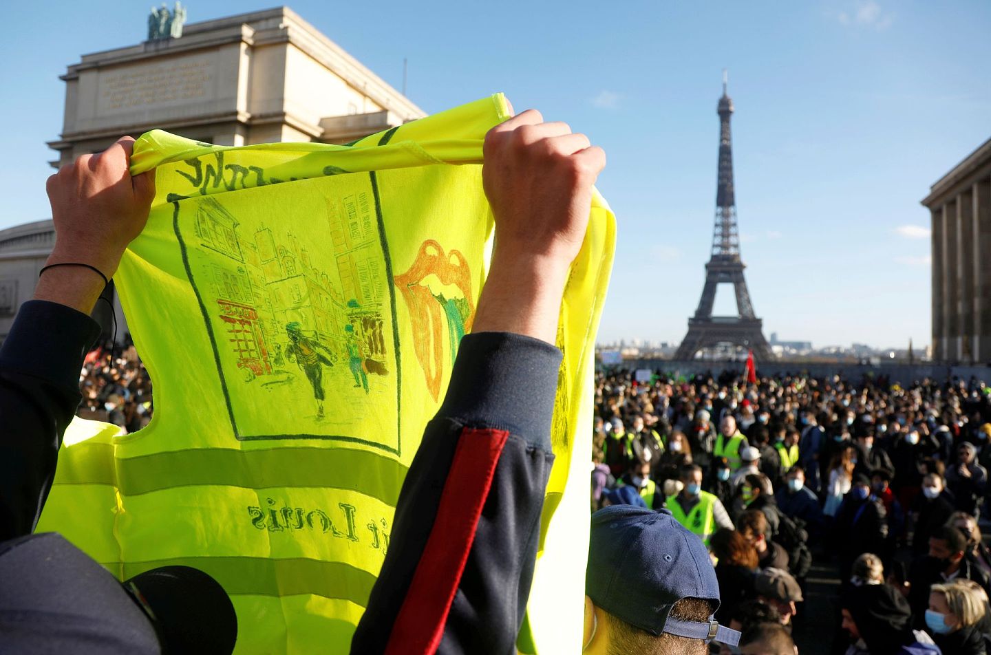 巴黎民众11月21日在特罗卡德罗广场示威，图为一名示威者高举一件黄背心。（Reuters）