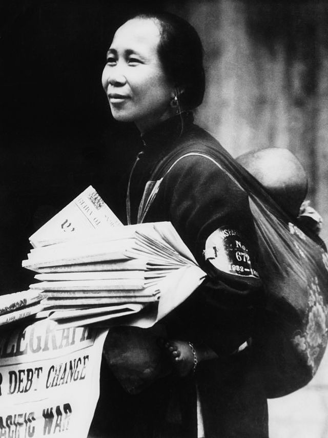 一名背着婴儿的妇女在香港街头卖报（1943年）