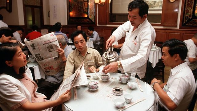 香港中环陆羽茶室内茶客边喝茶边读报（1986）