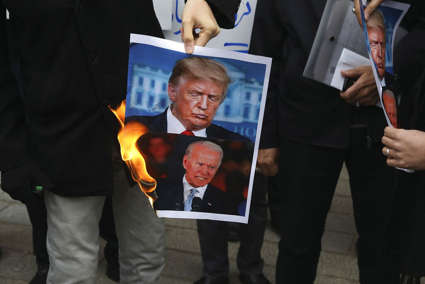 11月28日，一群示威者在伊朗外交部外点燃特朗普及拜登的照片。（AP）