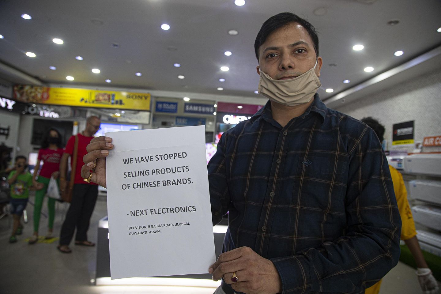 2020年6月18日，印度高哈蒂一家电器商店的负责人拿着抵制中国货的通知。（AP）