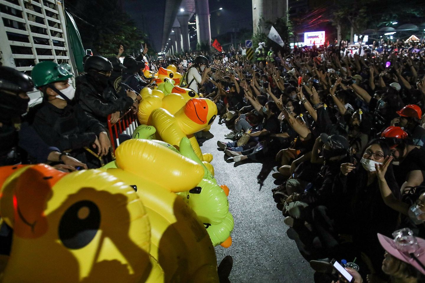 图为11月29日，示威者游行至曼谷一个军营外示威，示威者在警方架设的防线外聚集。（Reuters）