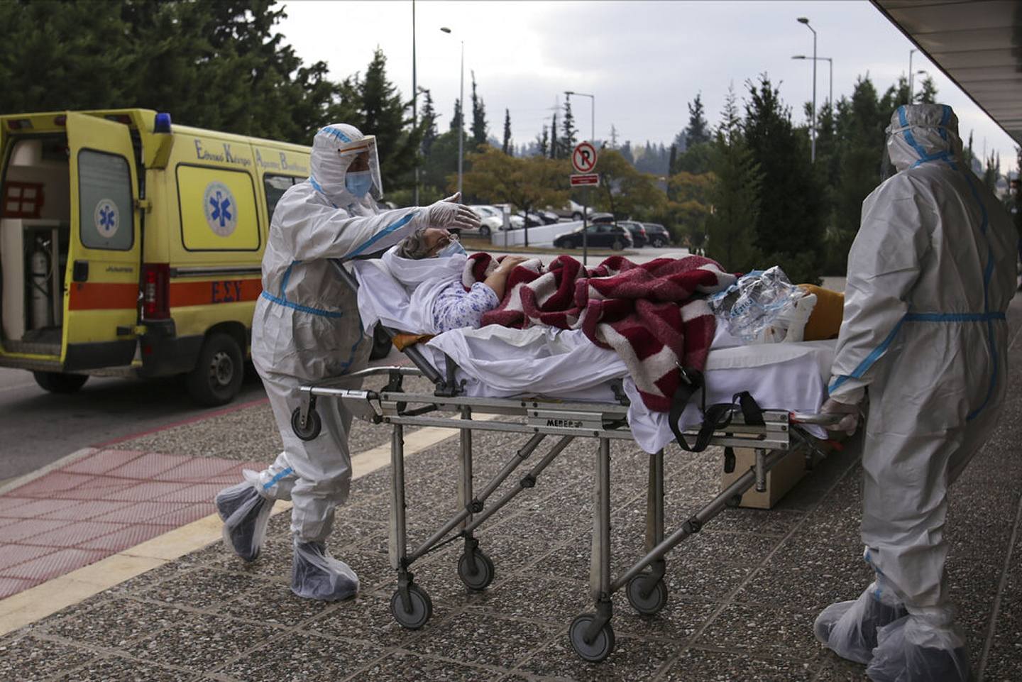 希腊新冠肺炎疫情：图为11月29日，医护人员在运送一名病人，协助此人从公立诊所转往私营诊所就医。 （AP）