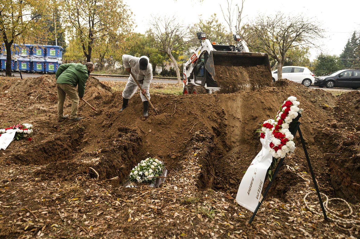 希腊新冠肺炎疫情：图为12月5日一位死于新冠肺炎的人下葬，工人正在用泥土覆盖棺材。（AP）