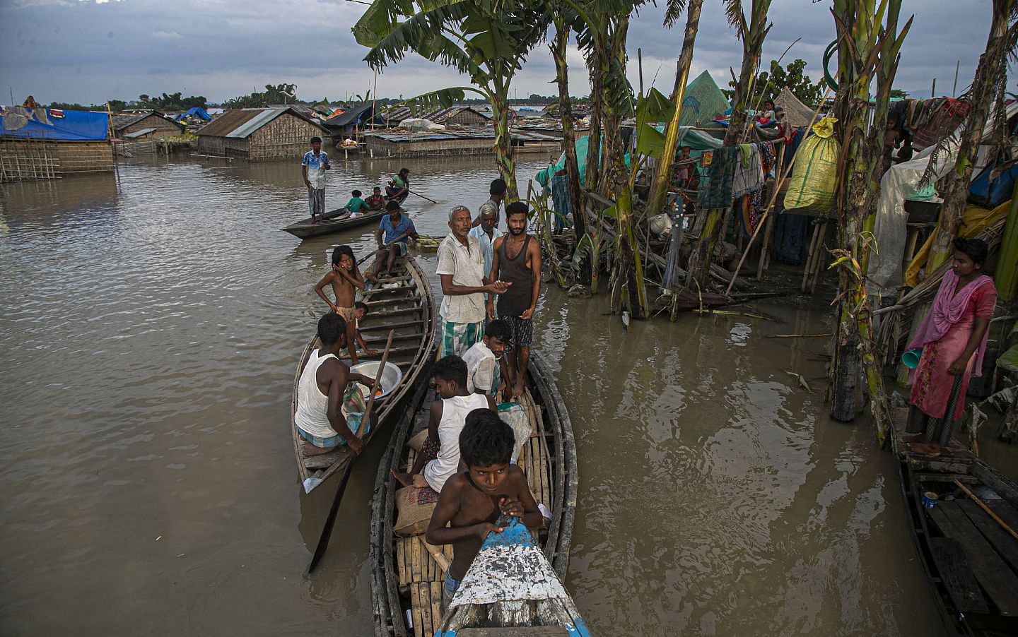 雅鲁藏布江的降强水经常给沿岸的印度居民带来洪灾。图为2020年7月印度阿萨姆邦（Assam）受洪灾影响的人们在被淹没的房屋附近的船上躲避。 (AP )