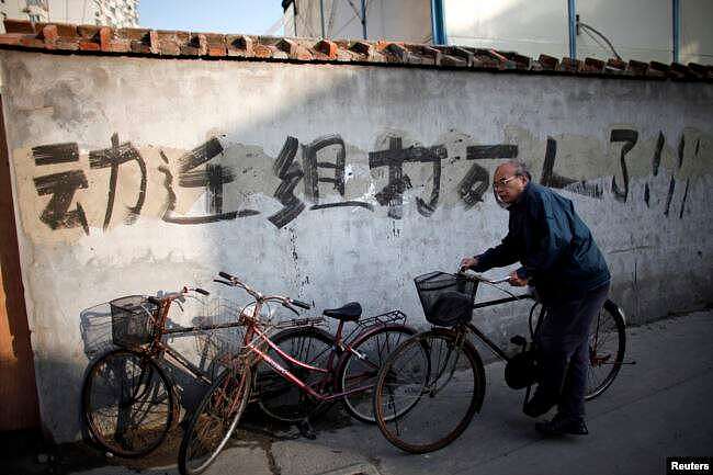 资料照：一名男子骑车走过上海街头一处拆迁地。（2010年12月1日）