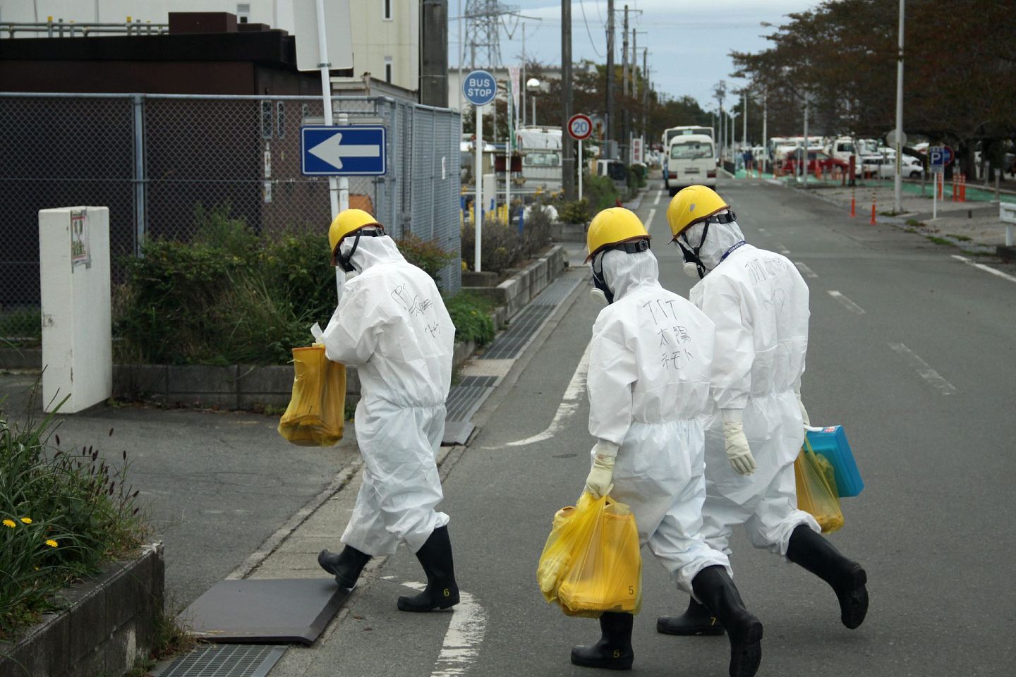 日本福岛核电站的安全性仍被外界质疑。图为2017年10月12日，身着核防护服的施工人员从日本福岛第一核电站内走过。（新华社）