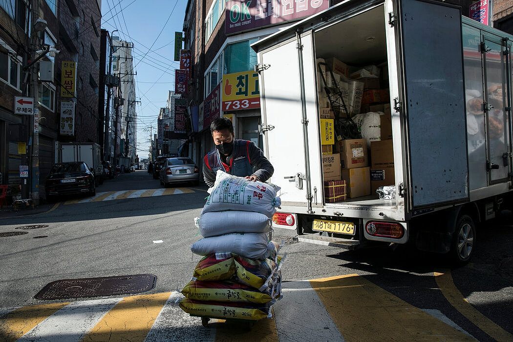 在韩国首尔的城南市，快递员朴基连为客户送大米。“我们也想在室内取暖，就跟我们所服务的人一样，”他说。