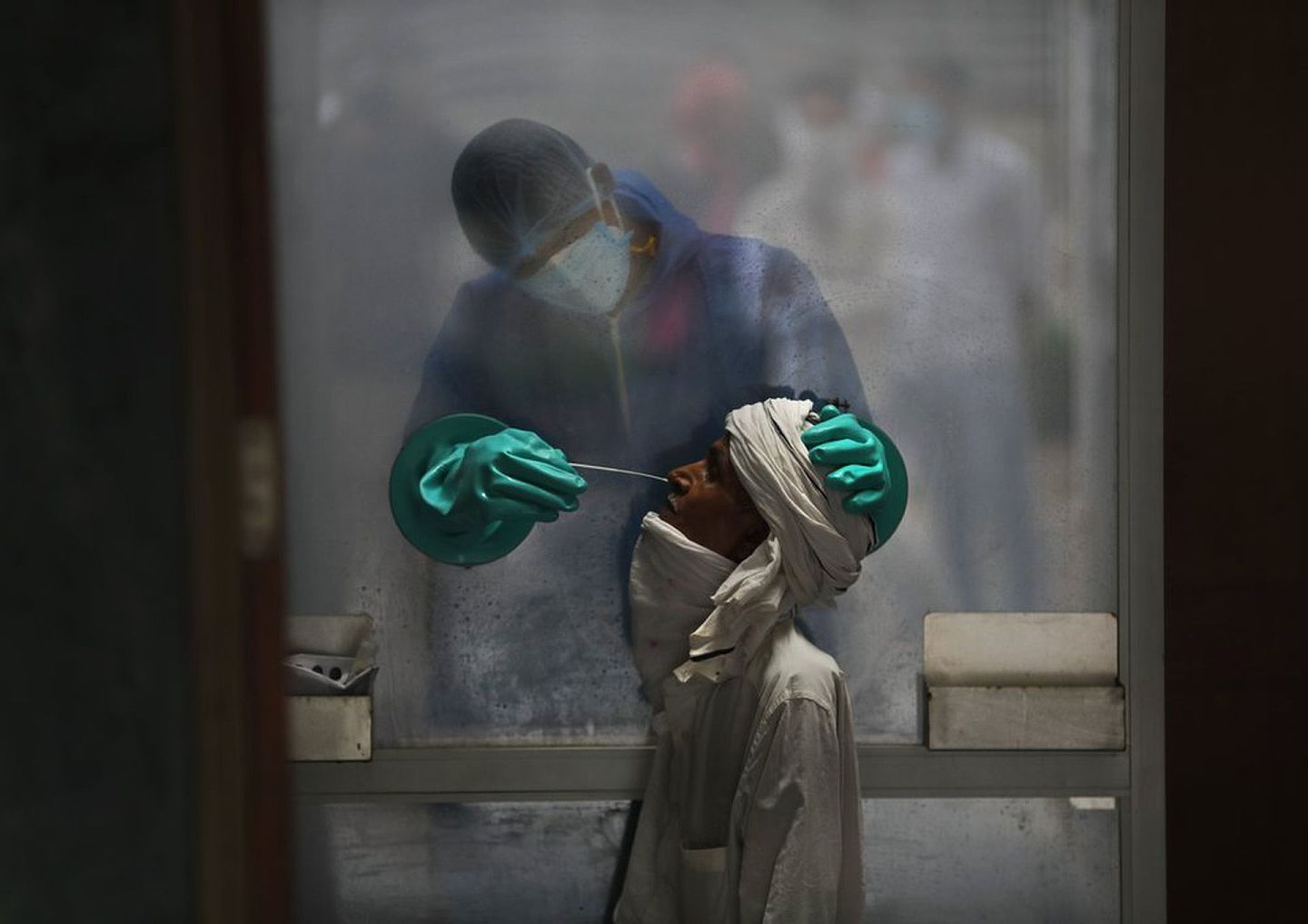 印度疫情在2020年下半年集中爆发，目前该国确诊总人数排名全球第二，图为新德里一家医院的医护人员进行病毒测试时的情景。（AP）