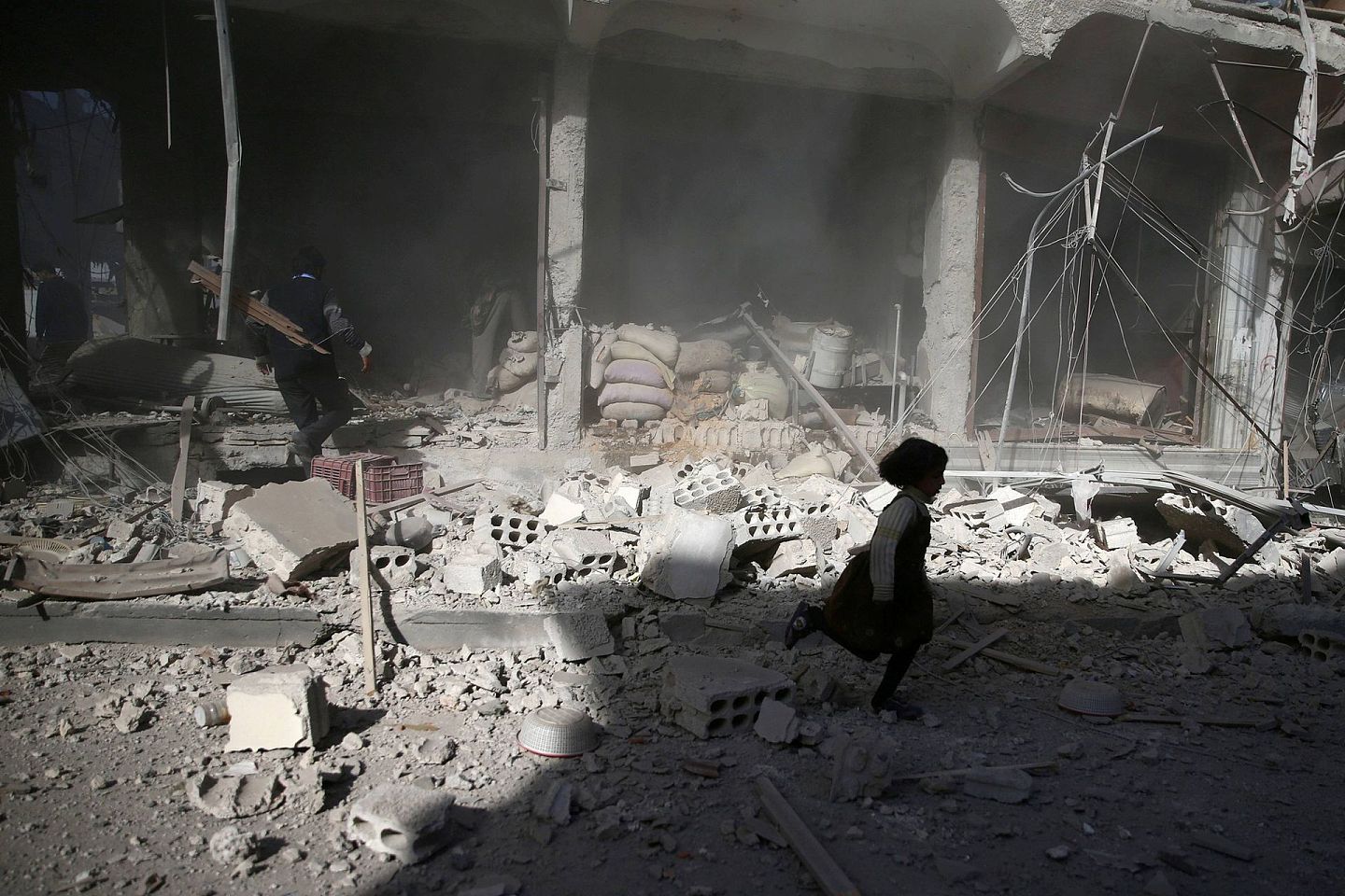 自2019年12月1日以来，包括57.5万多名儿童在内的96万人流离失所。图为2016年11月2日，一名女孩在杜马市遭空袭后从一片废墟上跑过。（Reuters）