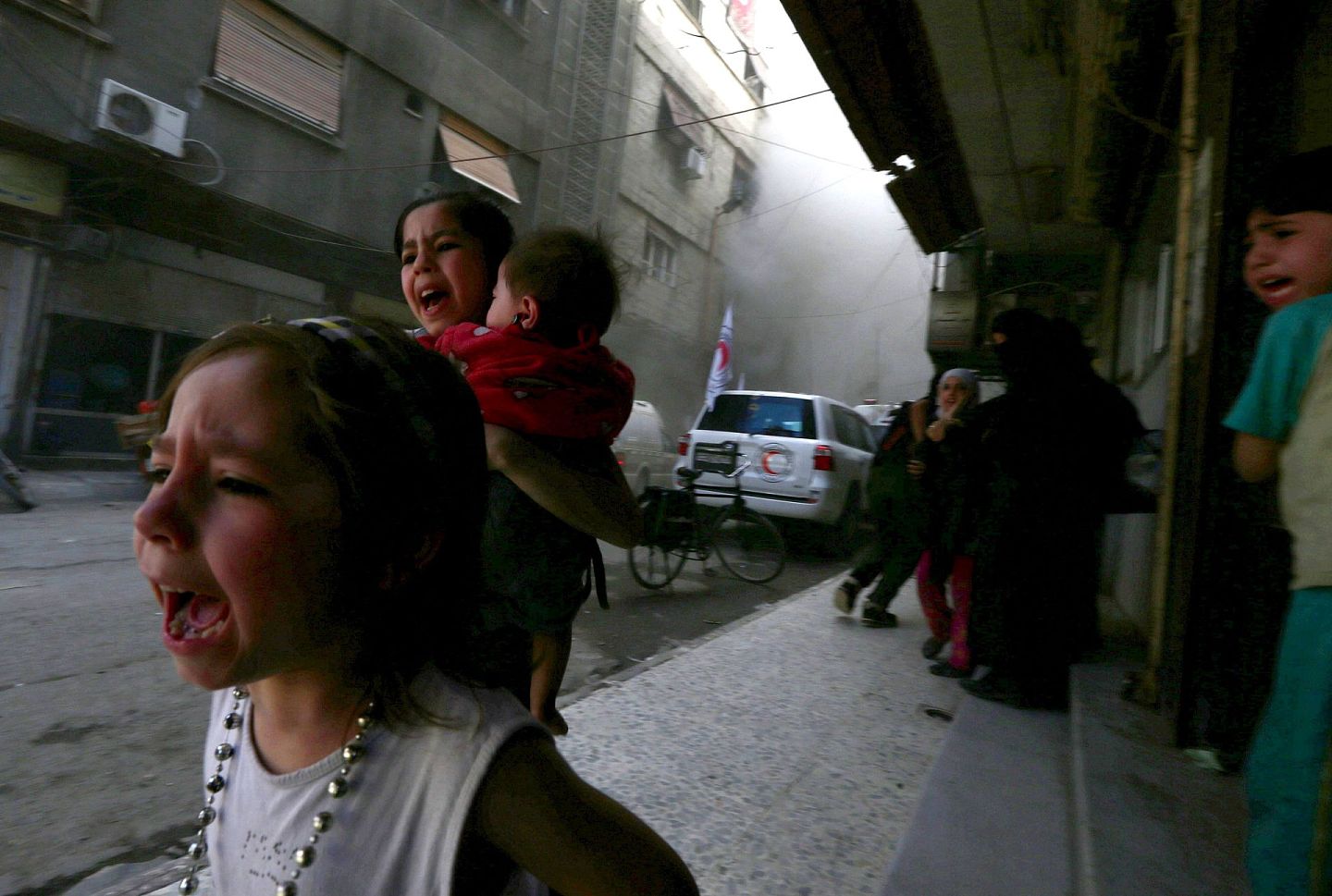 2015年5月6日，叙利亚政府军对西南部城市杜马进行空袭，儿童在叙利亚阿拉伯红新月会中心附近躲避。（Reuters）