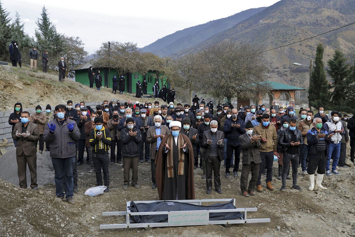 12月16日，伊朗人民聚集在北部城市加埃姆沙赫尔（Ghaemshahr）郊区一个公墓，为一名死于疫情的男子祈祷。（AP）