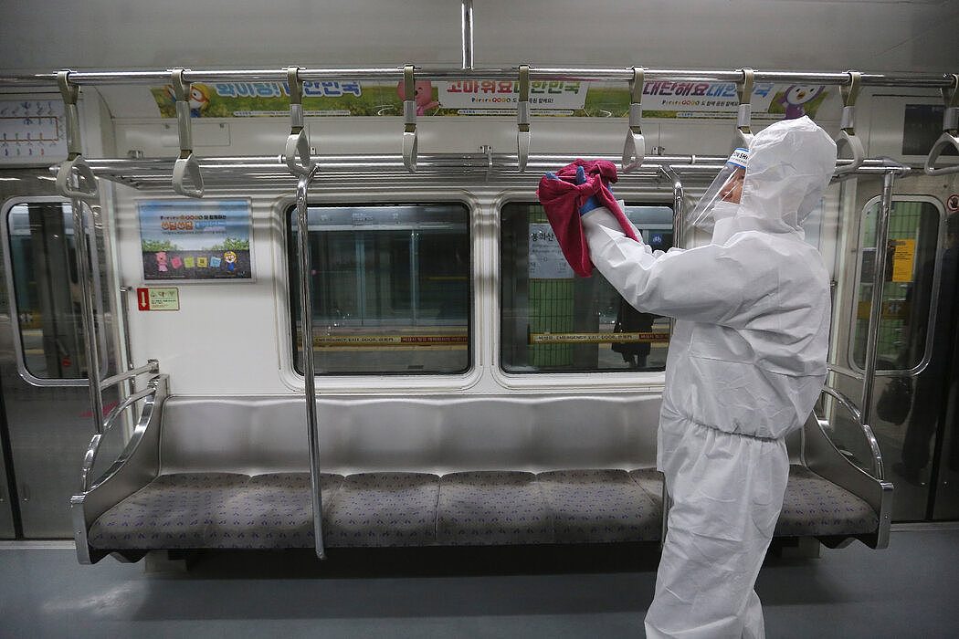 12月10日，一名工作人员在首尔地铁上对把手进行消毒，以预防冠状病毒感染。
