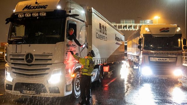 A police officer checks a lorry driver's phone at Dover Port, Kent, on Tuesday evening
