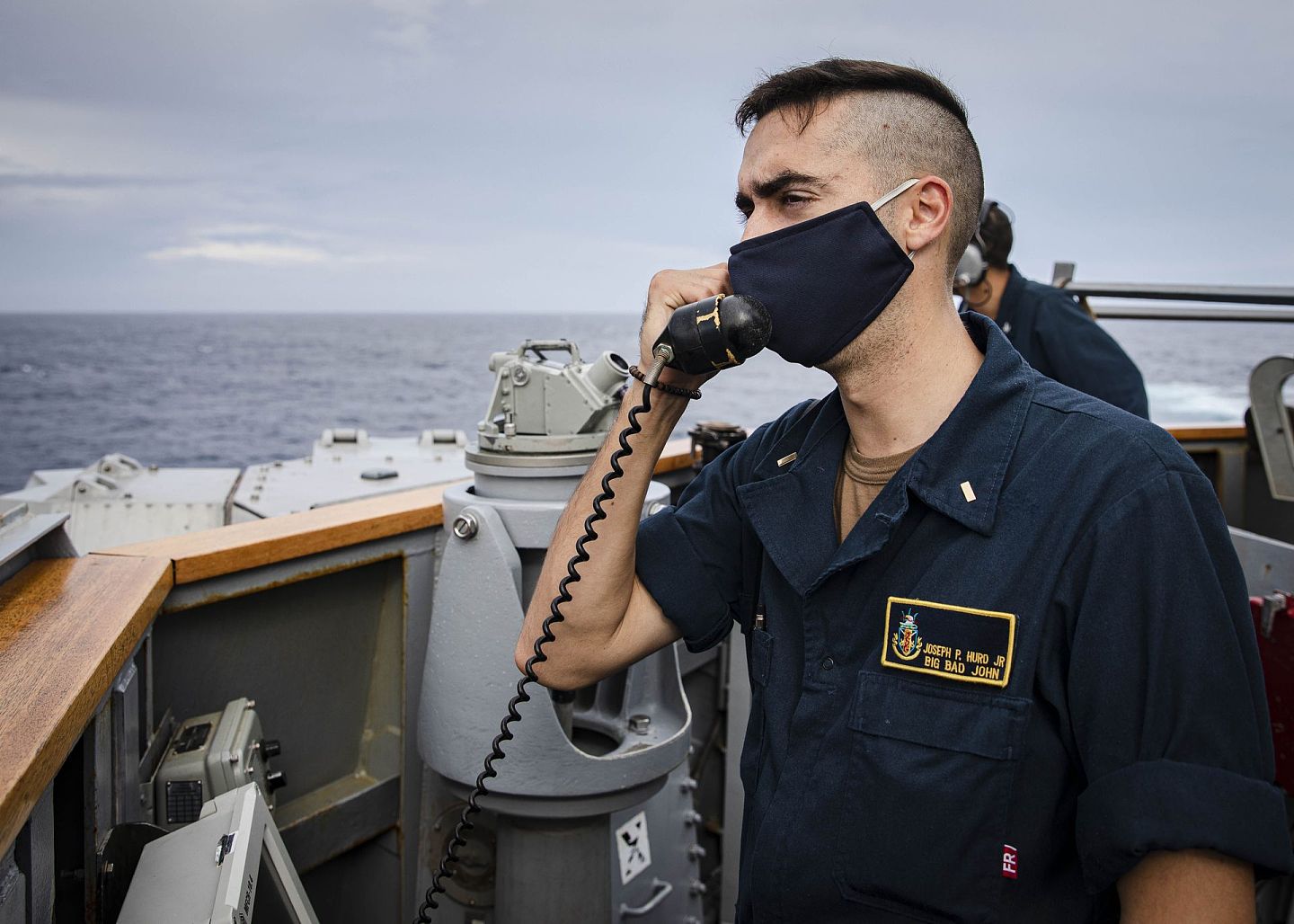 “麦凯恩”号驱逐舰上的一名士兵在甲板上拿起电话，与指挥室的人通话。（Twitter@7th Fleet）