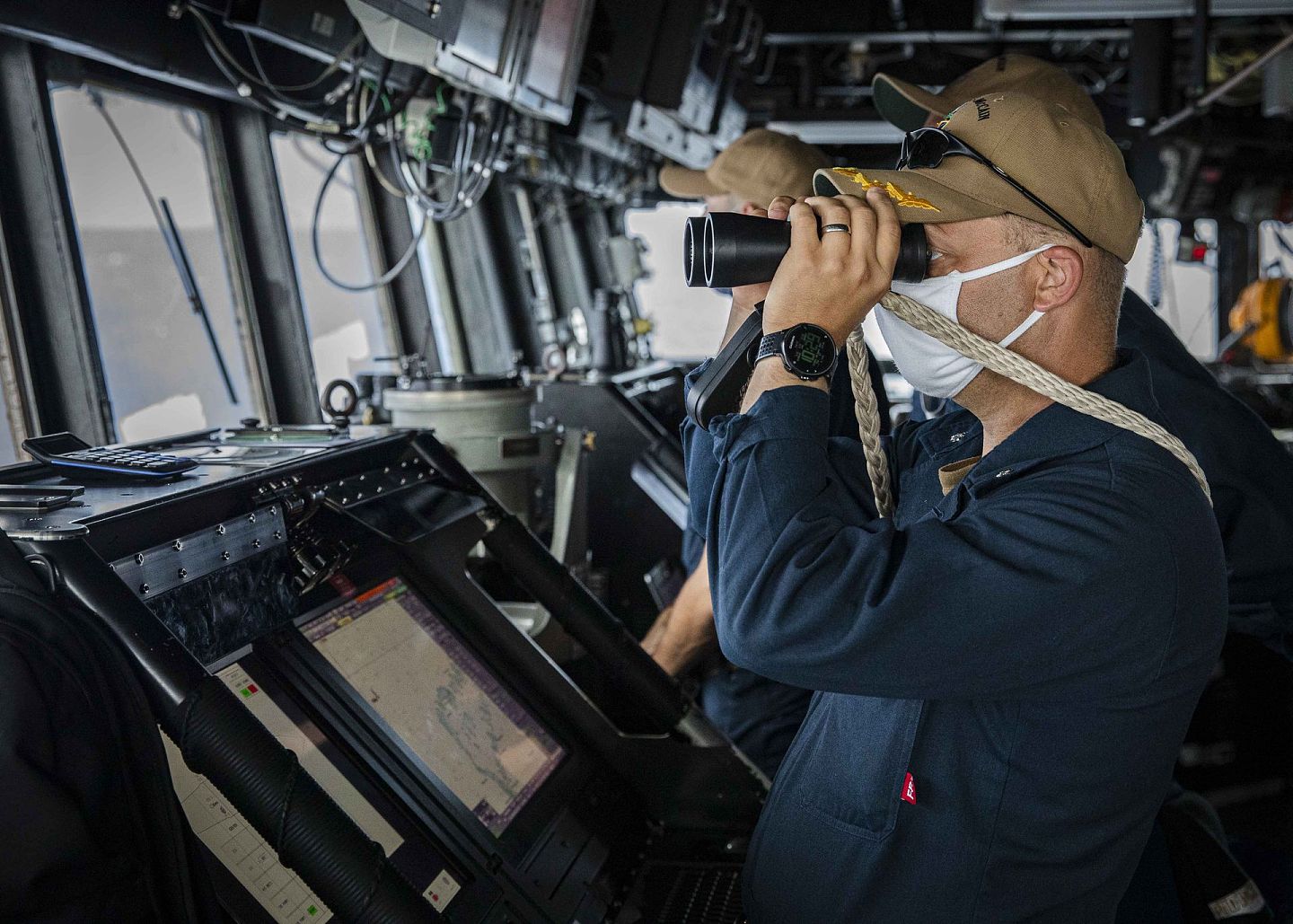 “麦凯恩”号驱逐舰上的一名士兵在指挥室内用望远镜侦查海上的状况。（Twitter@7th Fleet）