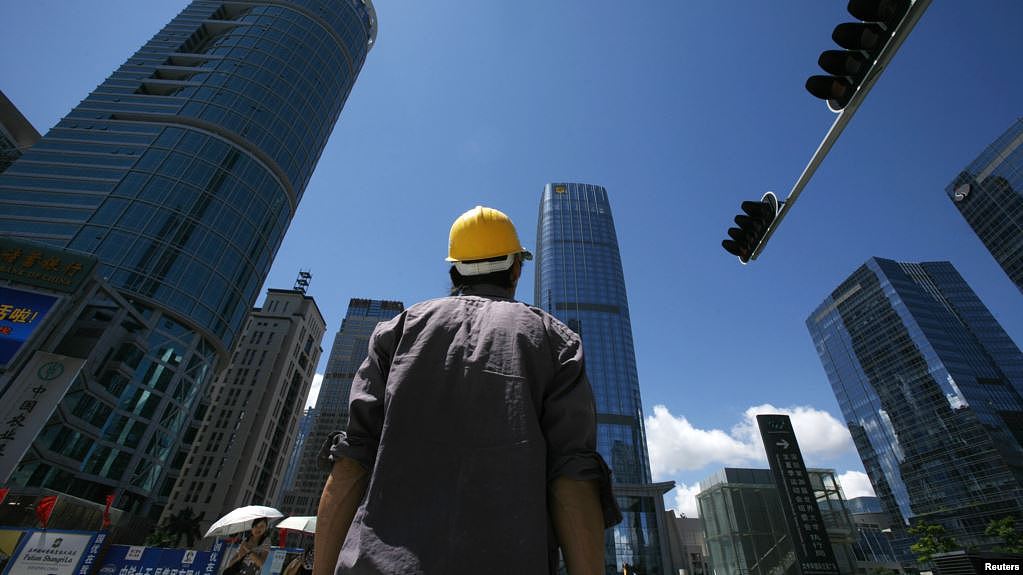 2009年7月16日，一名建筑工人在深圳商业区过马路。（路透社照片）