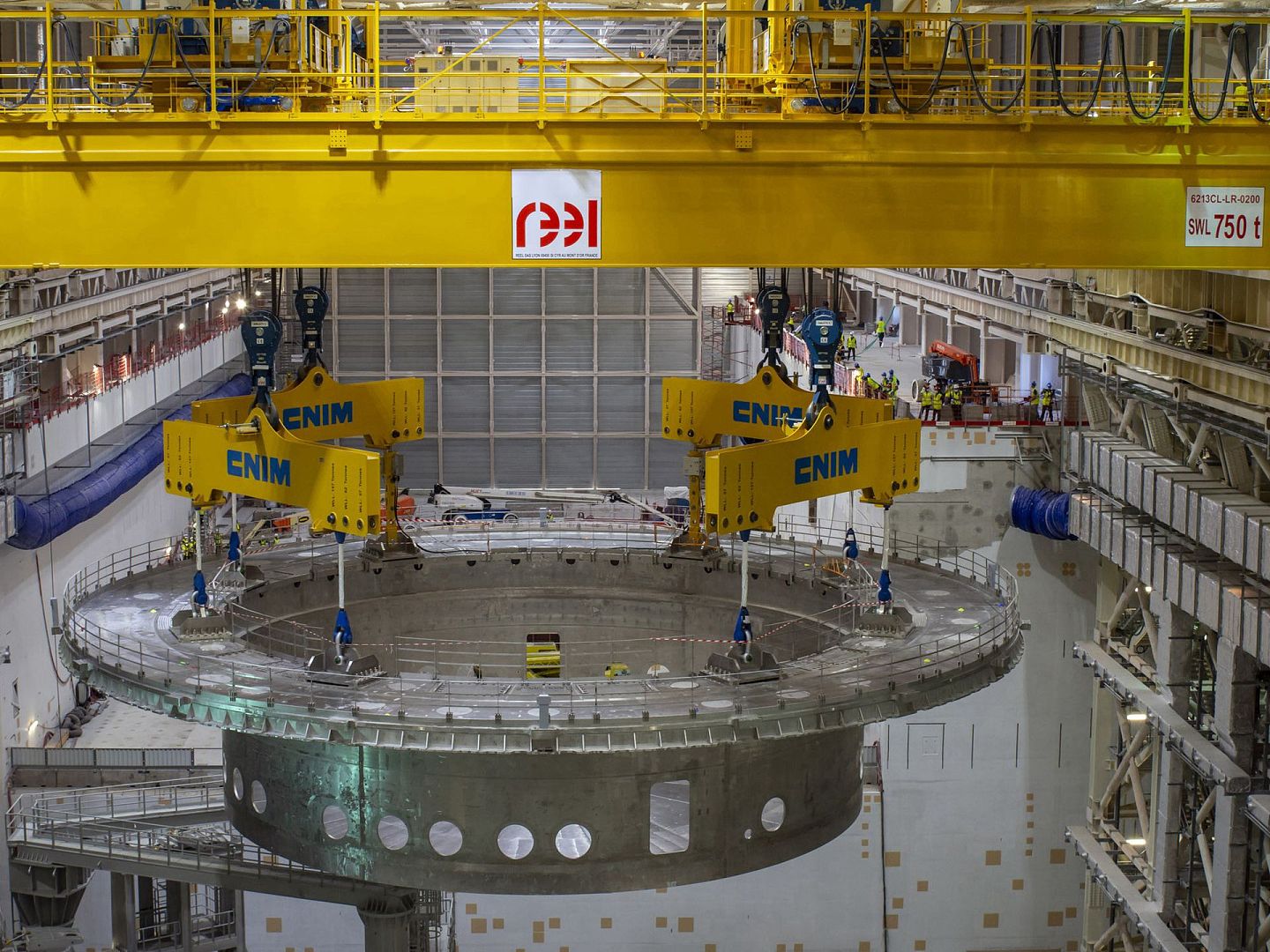 吊装中的重达1,250吨的ITER装置低温恒定器底座。这一安装工程由中国核工业集团与法国合作方中标，底座已于2020年5月安装完毕。（ITER官网）